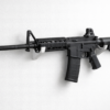 Horizontal gun wall rack holding a tactical rifle securely on a clean white wall