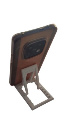 Portable phone stand folded completely flat next to a laptop for travel