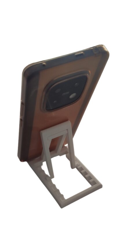 Portable phone stand folded completely flat next to a laptop for travel