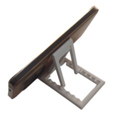 Portable phone stand folded completely flat next to a laptop for travel